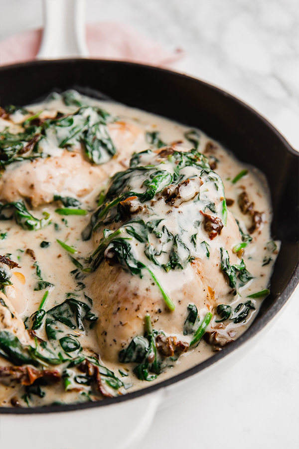 A pan with Tuscan chicken skillet after it has finished cooking.