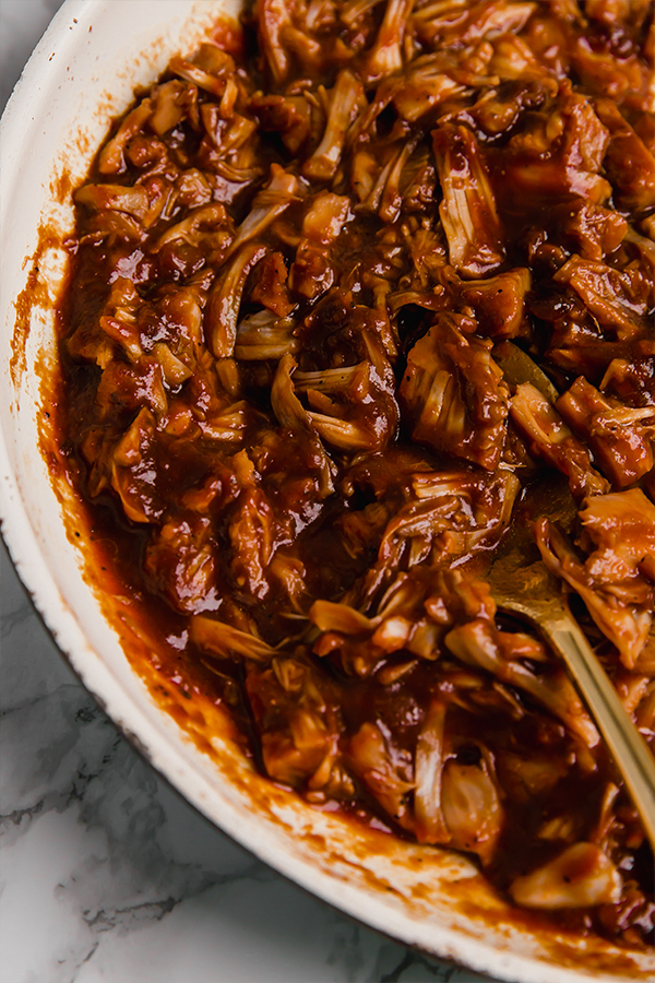 A serving bowl filled with BBQ jackfruit topped.