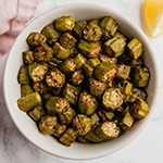 A white bowl filled with oven roasted okra.