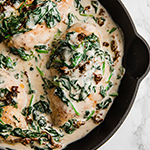 A pan with Tuscan chicken skillet after it has finished cooking.
