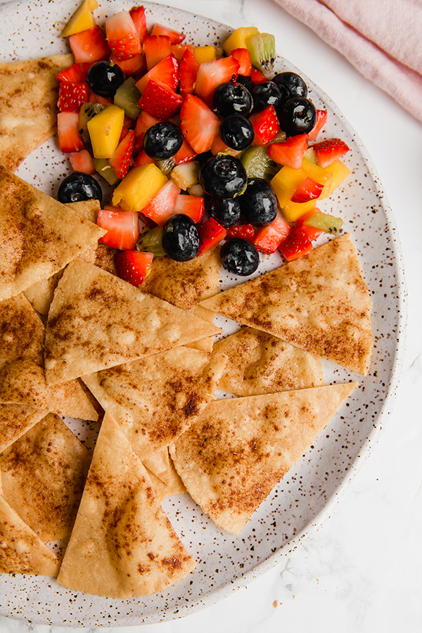 A speckled plate with grain-free cinnamon sugar chips with fruit salsa.