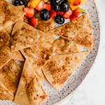 A speckled plate with grain-free cinnamon sugar chips with fruit salsa.