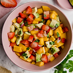 A pink bowl filled with strawberry mango salsa.