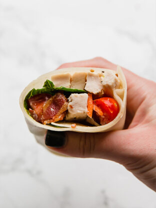 Person holding a chicken bacon ranch wrap.