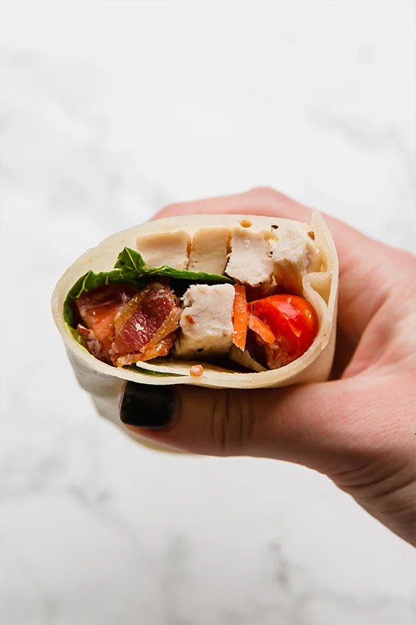 Person holding a chicken bacon ranch wrap.