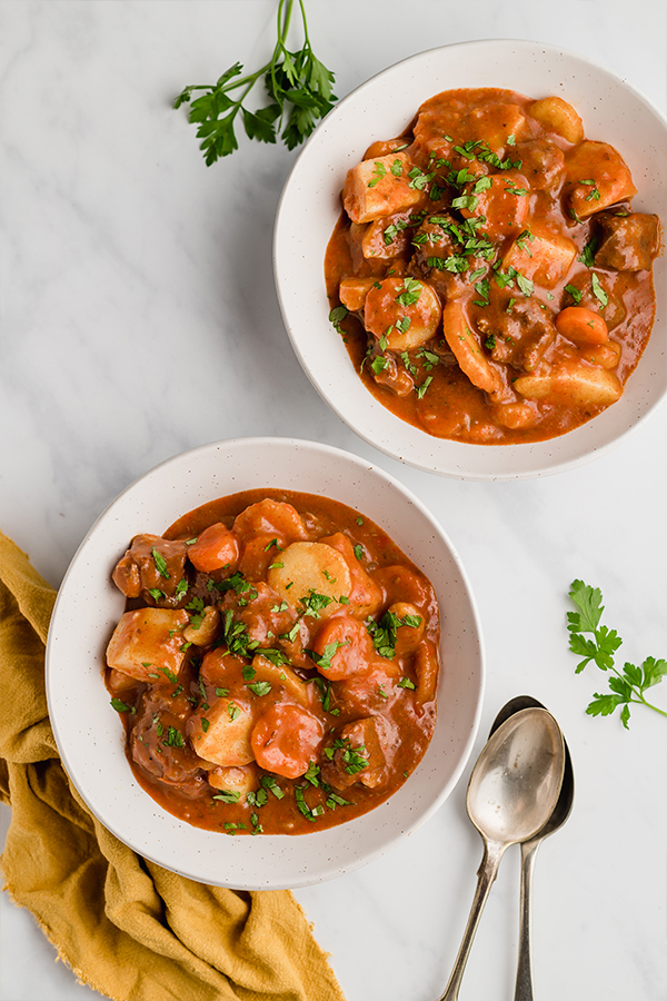 Two white bowls filled with authentic Hungarian goulash.