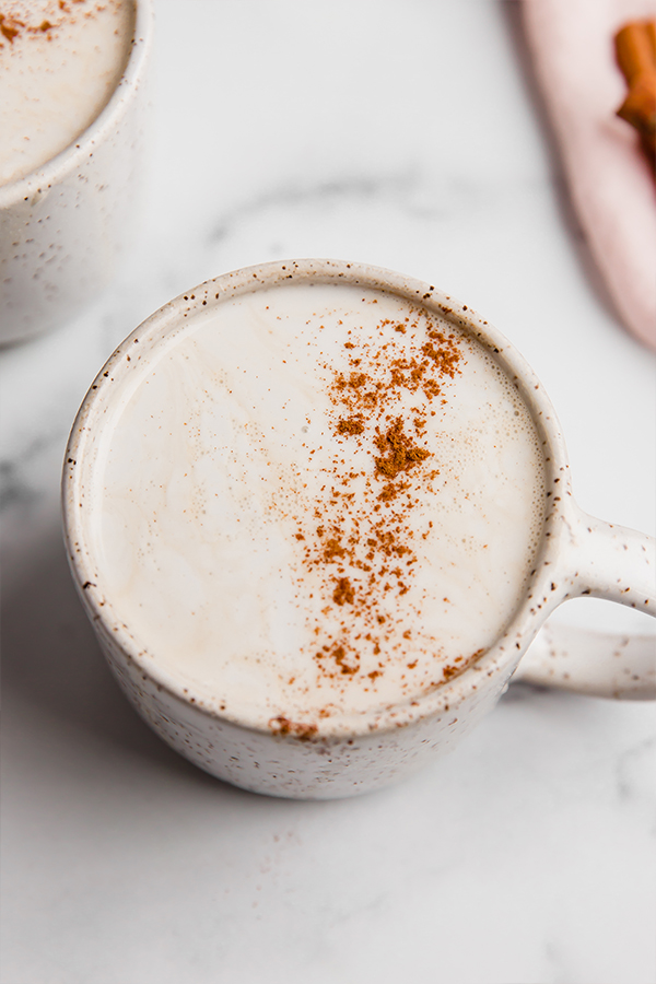 A white ceramic mug filled with a snickerdoodle latte.