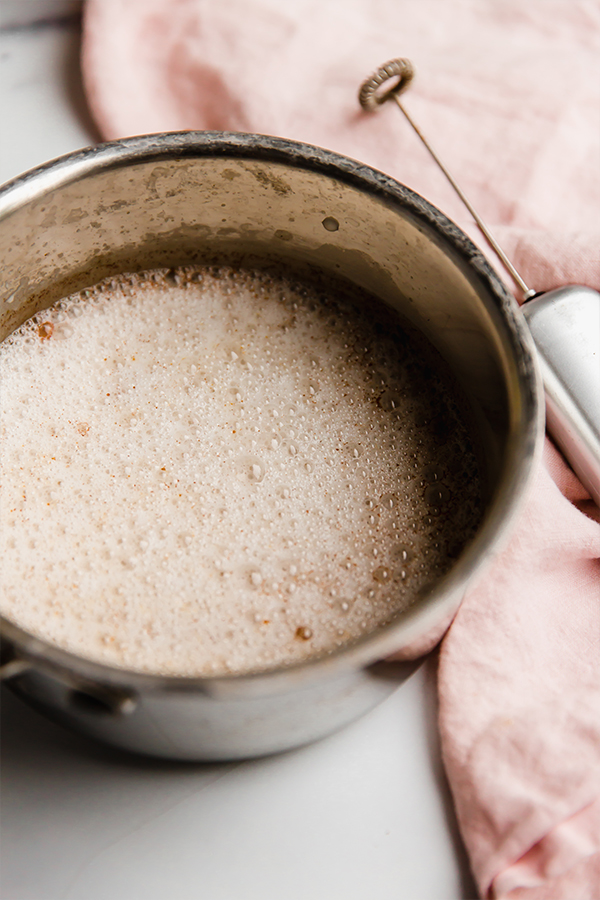 A mug with snickerdoodle latte before being topped.