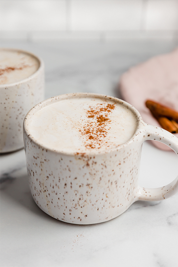 A white ceramic mug filled with a snickerdoodle latte.