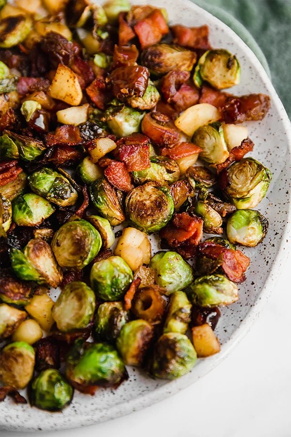 A speckled plate covered in bacon date & apple brussel sprout skillet.