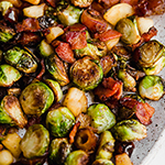 A speckled plate covered in bacon date & apple brussel sprout skillet.