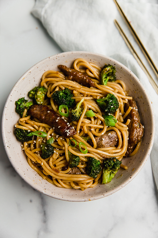 gluten-free beef and broccoli lo mein on plate with chop sticks