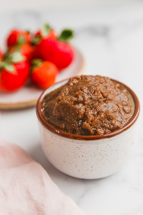 cookie butter in cup with strawberries on plate