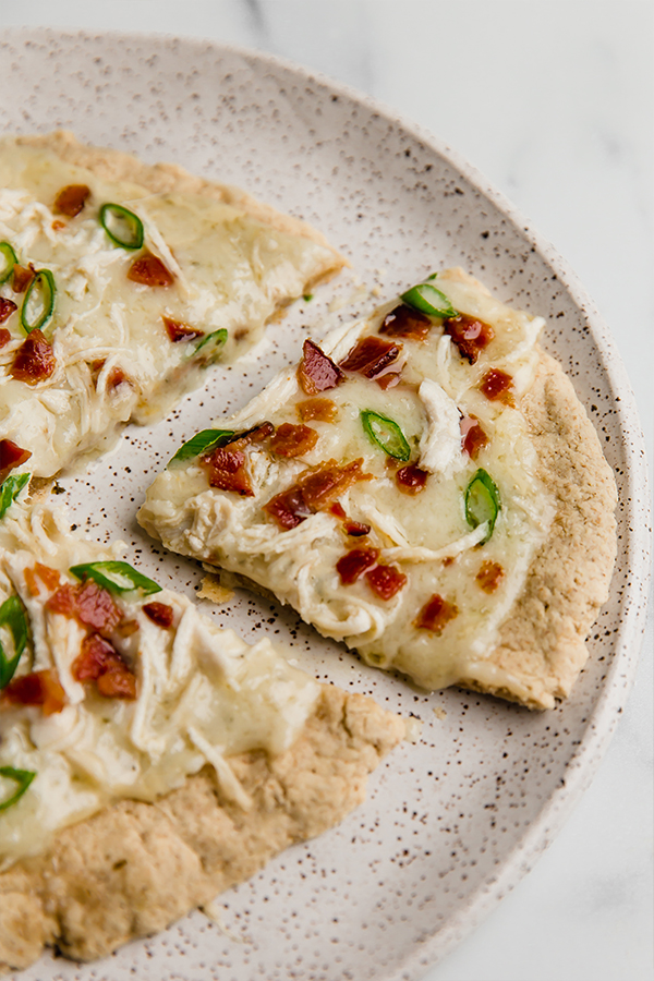 bacon ranch pizza on plate with slice