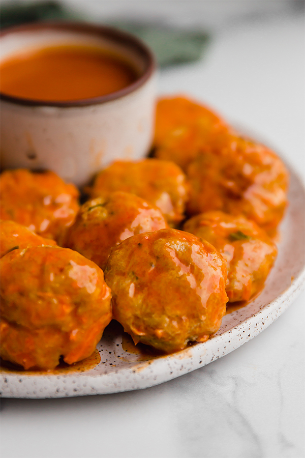 buffalo chicken poppers on plate with sauce