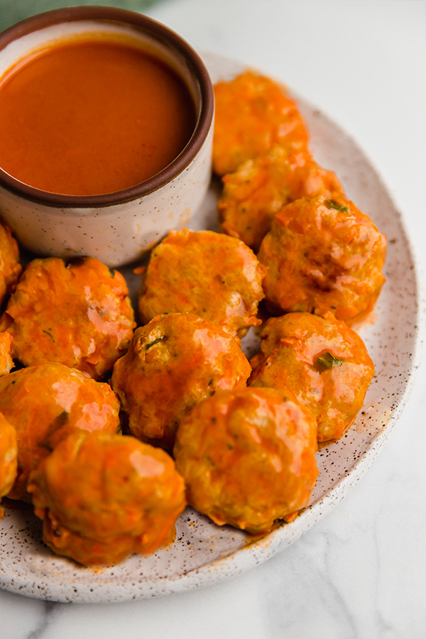 buffalo chicken poppers on plate with sauce