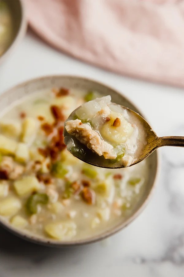 A spoonful of clam chowder taken out of the bowl.