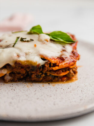 Sweet potato lasagna on a plate topped with basil.