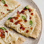 Bacon ranch chicken pizza topped with bacon and green onion