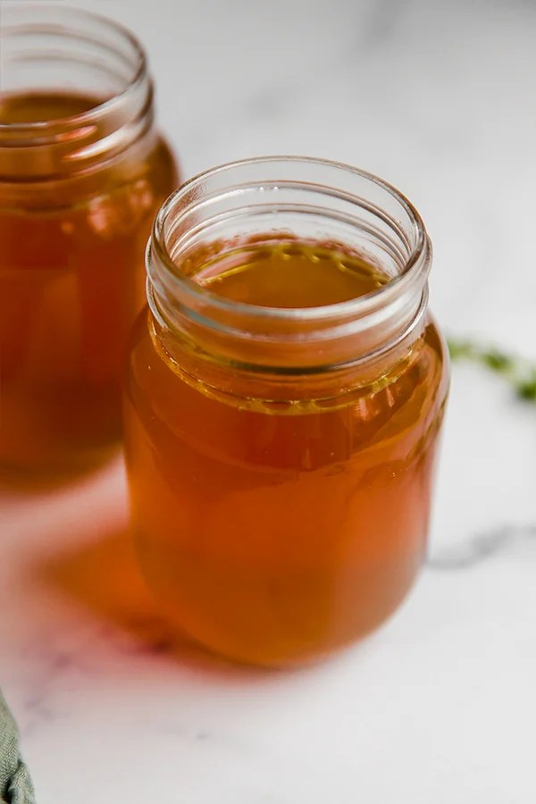 Two glass jars of bone broth.