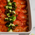 Chicken enchiladas in a baking dish.