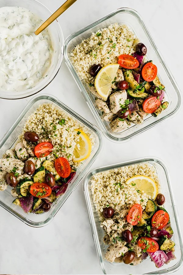 Several containers of Greek chicken meals.