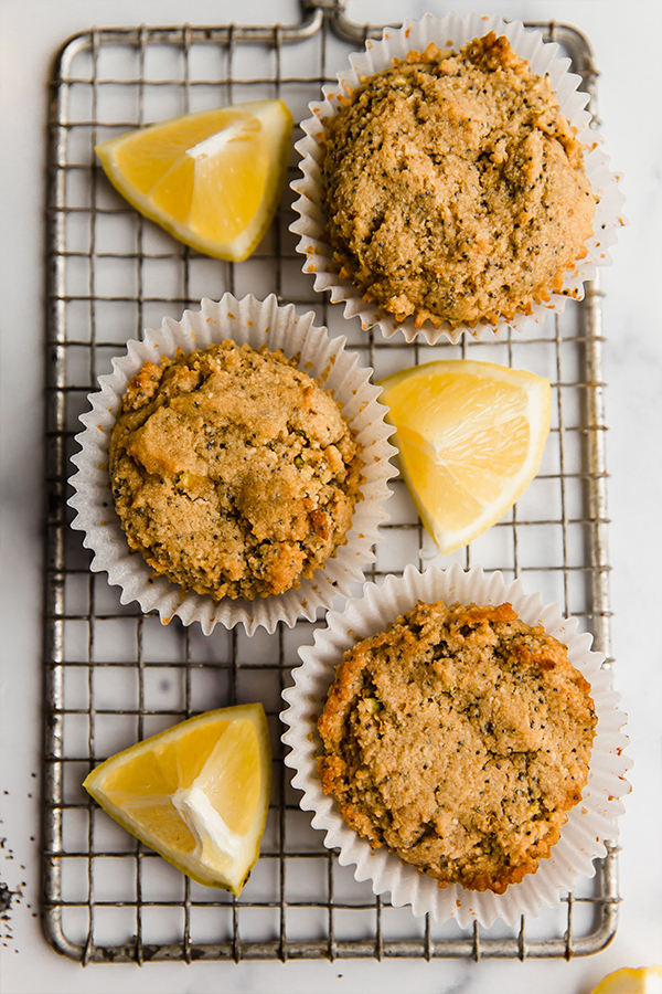 Three lemon zucchini muffins with lemon wedges