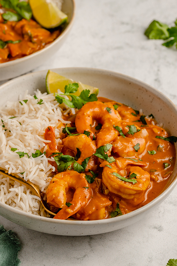 Shrimp curry in a bowl with rice and a fork.
