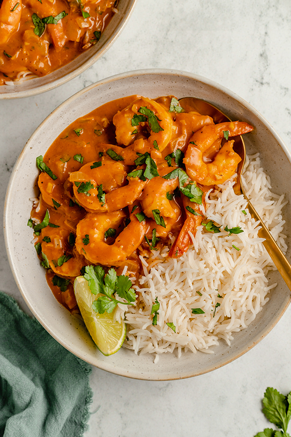 shrimp curry in a bowl with rice and lime