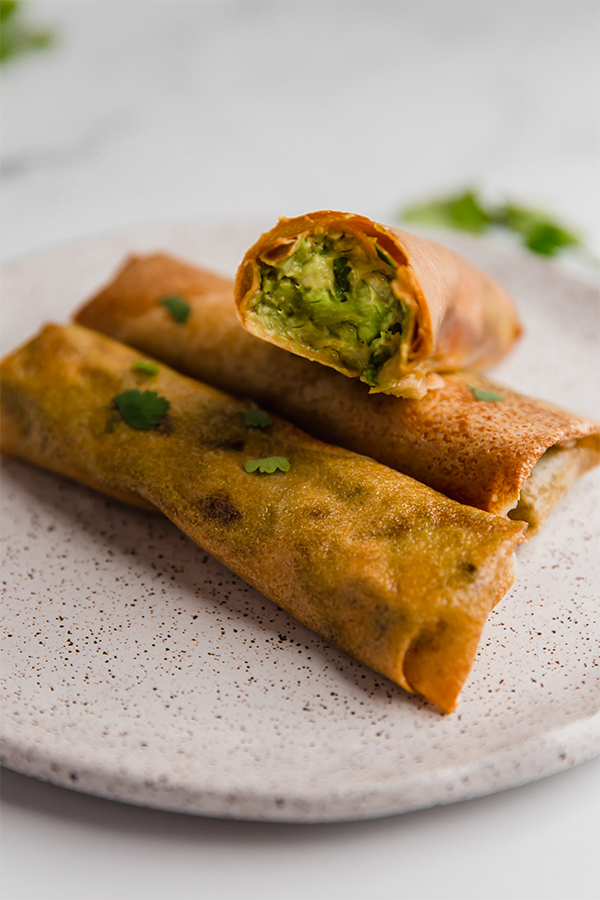 Avocado egg rolls on a plate.