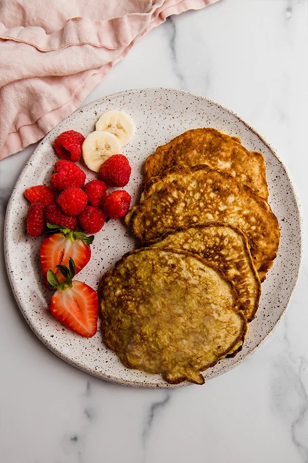 Fruit and banana pancakes on a plate.