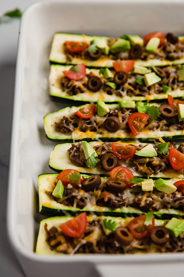 Taco-stuffed zucchini boats in a baking dish.