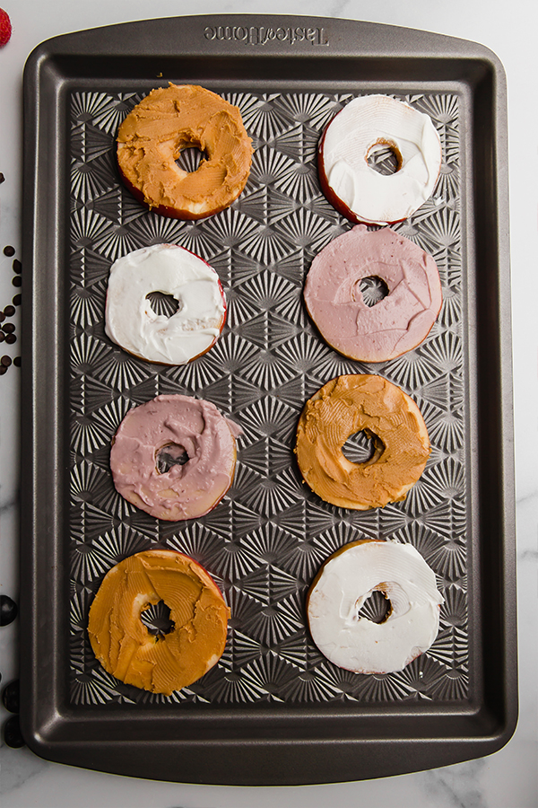 Apple slices on sheet pan with almond butter and coconut yogurt spread on top