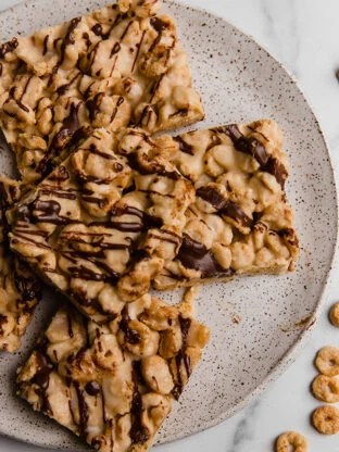 Cereal bars drizzled with chocolate on a plate.