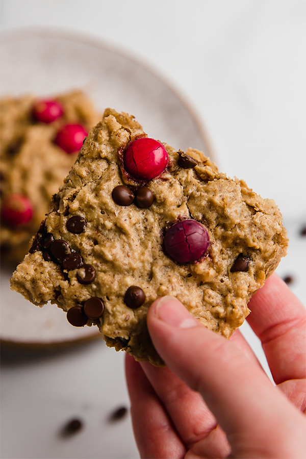 Person holding a monster cookie oatmeal breakfast bar.