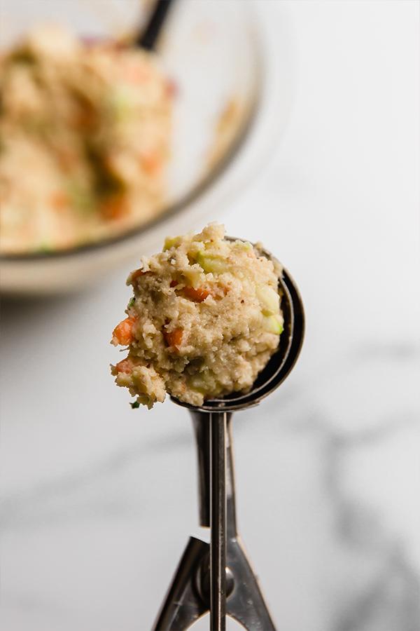 Spoon with a scoop of veggie muffin mixture.
