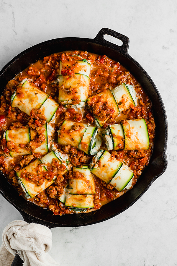 Top view of zucchini roll ups in cast iron pan on counter