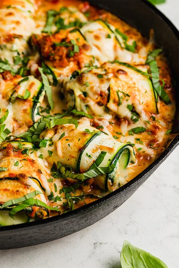 Zucchini roll ups topped with melted dairy-free cheese.
