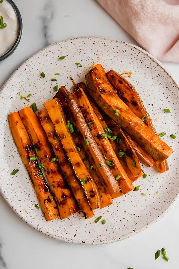 Grilled sweet potato fries piled on a plate.