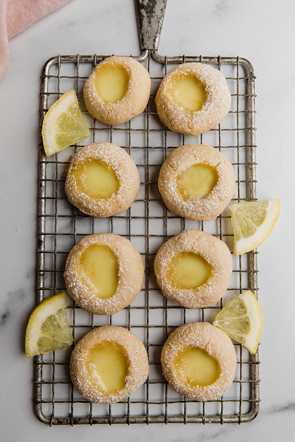Lemon bar thumbprint cookies on a wire rack.