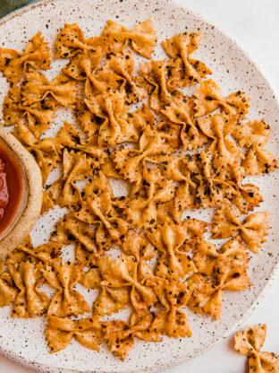 Pasta chips on a plate with dip.