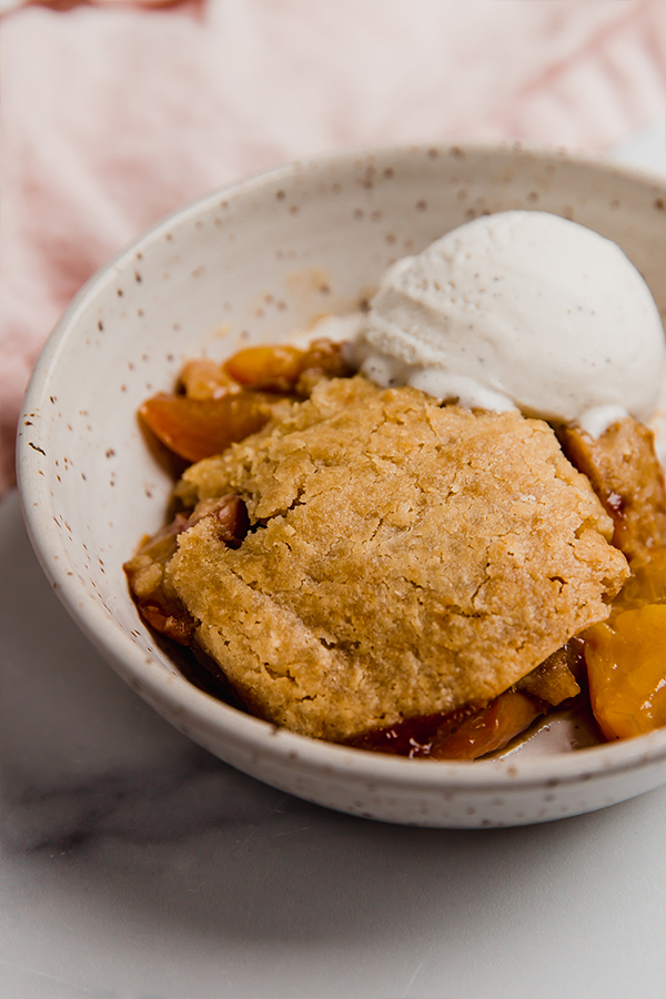Peach cobbler with a scoop of ice cream.