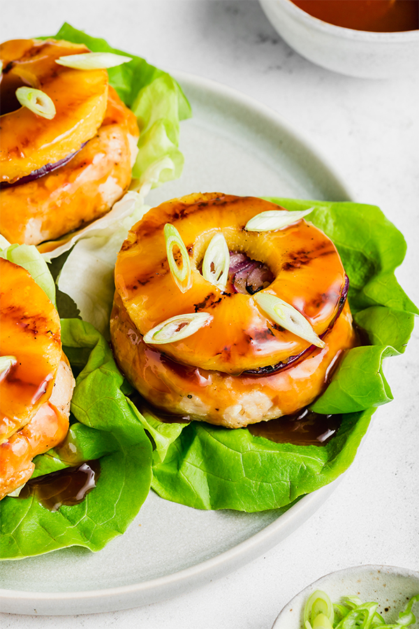 Sweet and sour chicken burgers topped with a pineapple slice.