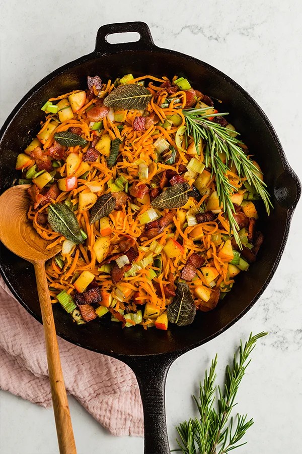Carrot, apple, and bacon breakfast hash in a skillet.