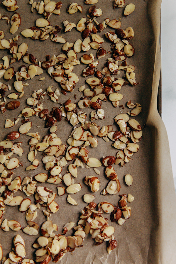 Almonds on a lined baking sheet.