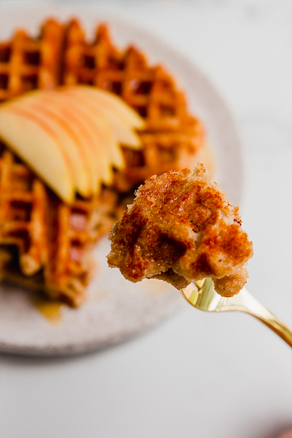 A bite of gluten-free apple waffle on a fork.