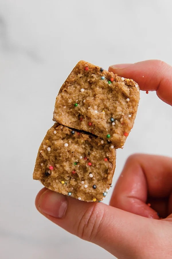 Person holding two cake batter protein bars.