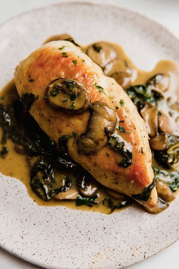 Chicken breasts with spinach and mushroom sauce served on a plate