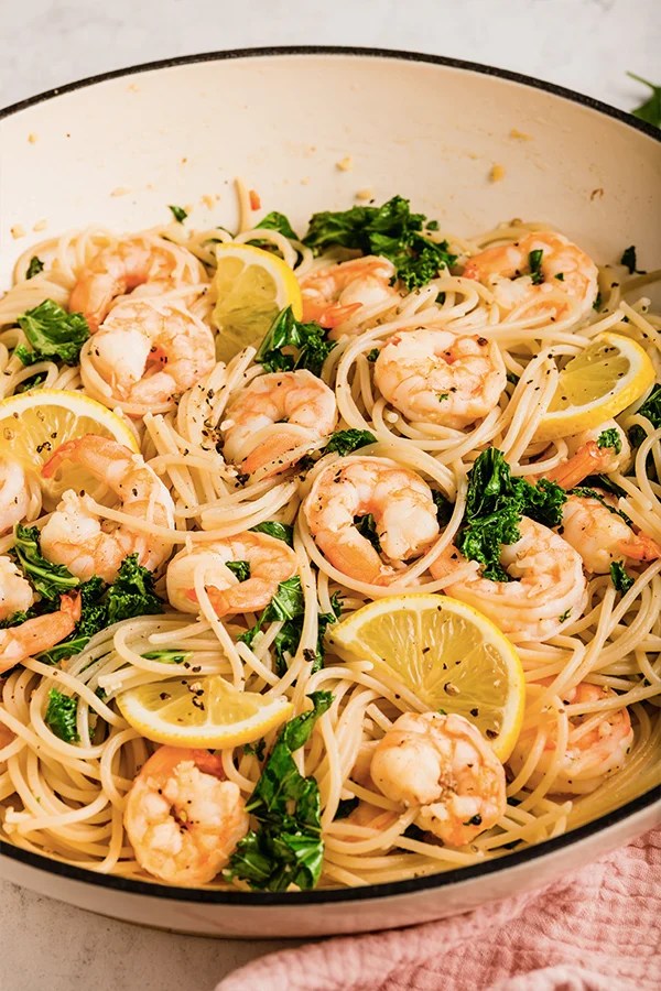 Lemon garlic shrimp pasta cooked in a pan with lemon slices