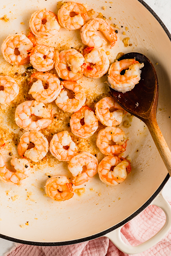 Shrimp cooked in pan with wooden spoon